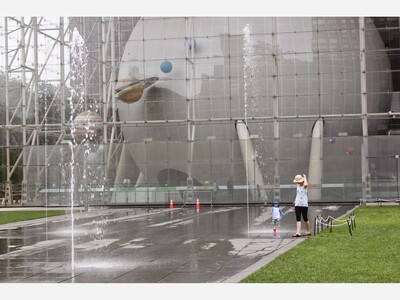 Arthur Ross Terrace features sprinklers, trees, and shaded cafe tables. 